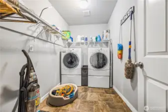 Spacious laundry room with built-in shelving and durable flooring, conveniently located near upstairs bedrooms (between flex room and bedroom 5)