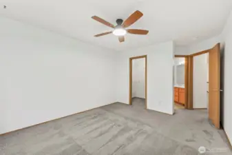 Primary bedroom looking out toward walk-in closet, en-suite bathroom and the hallway