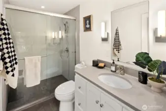 Remodeled primary ensuite with a sleek glass-enclosed shower, modern tilework, and clean, timeless finishes — a private, serene space designed to start and end your day comfortably.