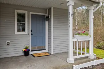 Covered front porch for seasonal decor or quiet morning coffee.