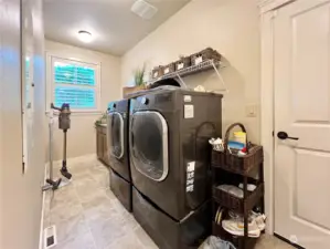 Large well lit laundry room, door to the right is the 3 car garage access.