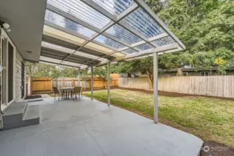 Back yard concrete Patio w/overhang. Freshly mowed, edge and new mulch in bedding.