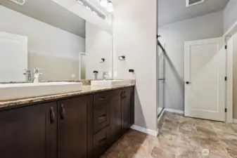 Beautiful ensuite primary bath with vessel sinks and tile step-in shower