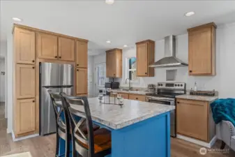 Kitchen w/ island and stainless steel appliances and hood.