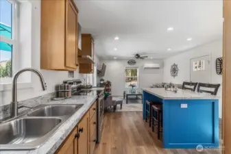 Kitchen w/ stainless steel appliances, hood and sit up island.