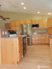 Kitchen with new refrigerator and microwave.