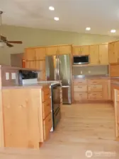 Kitchen with new refrigerator and microwave.