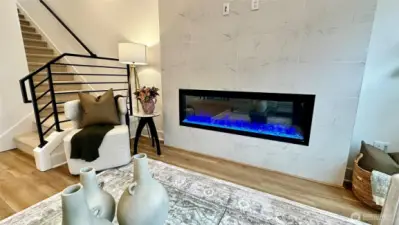 Cozy fireplace with power and conduit to hand a tv over it (staging and furniture are for decoration and not included in the sale of this home)