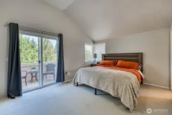 The wonderful primary suite, with a private balcony that has filtered views of downtown Seattle.