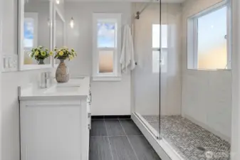 Thoughtfully designed for relaxation and function, the tile, double vanity, custom lighting, shower door, and windows are gorgeous.