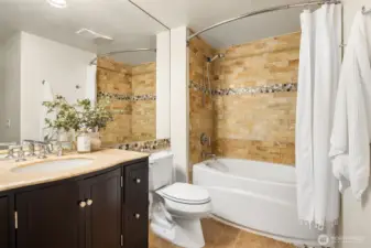 Full continental bath with tile floors, vanity with solid surface counter, and deep tub