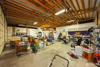 Access the spacious 3 bay garage from the hallway outside the "man cave".   Currently a staging areas for moving...this large three bay garage does more than store cars, trucks or an RV.  It has a loft with more storage below as well as above.