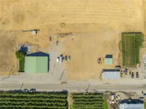 Drone visual of the house, with shop and hay shed to the right, surrounded by pasture.