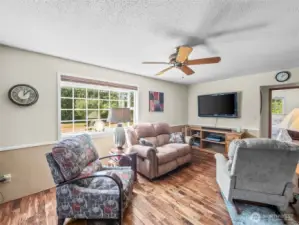family room with wood burning stove and entry to primary hallway and bedroom