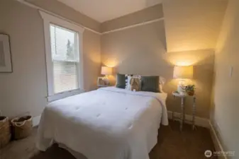 In one of the two main floor bedrooms, you will love the space, light, and original charm - including the picture ledge adorning the top of the walls adding both charm and function.