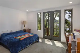 Primary bedroom with deck access and hot tub with views of the resort.