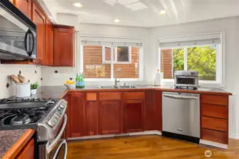 The spacious kitchen has granite counters and stainless steel appliances, including a 6-burner stove with a double oven and sleek built-in fridge.