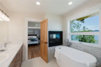 The connected primary bathroom has a soaking tub , double vanity sinks, quartz countertops. Soak in the tub and enjoy the views and warmth from the fireplace.