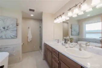 Double sinks and quartz countertops in the primary bathroom.