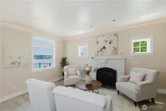 The stunning living room with gas fireplace.  A beautiful antique carved Carrera marble fireplace surround and keystone and slate hearth has been artfully adapted to this modern gas fireplace.