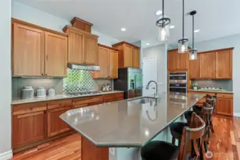 Kitchen with slab granite counters, 42" cherry cabinets with undermount lights, tile and stainless backsplash. The island counter provides plenty of prep space and counter seating.