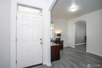 The entryway opens to a versatile multi-purpose room, perfectly suited for a home office, library, sitting area, or personalized use.