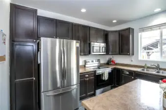The kitchen features sleek stainless steel appliances and abundant cabinetry for ample storage.