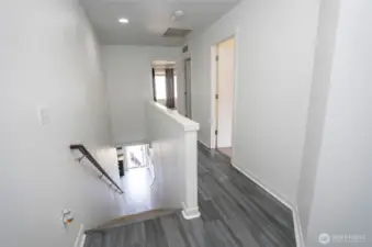 Spacious upper-level landing leads to the primary suite, three guest bedrooms, and a conveniently located laundry room for added ease.