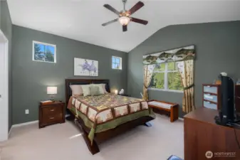 Primary bedroom with vaulted ceiling, walk-in closet, and primary bathroom with newly updated shower.