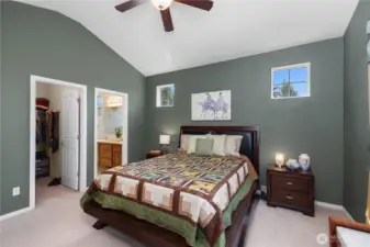 Primary bedroom with vaulted ceiling, walk-in closet, and primary bathroom with newly updated shower.