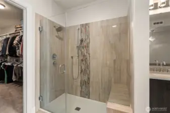 Dual shower heads with a bench seat make this primary shower very versatile