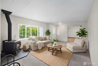 First living space directly to right of entryway. This space is filled with natural light, notice the newer carpeting, and cozy wood burning fireplace ! Photo is virtually staged.
