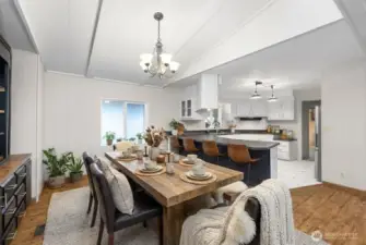 A close up view of your dining space with built in cabinetry directly off the kitchen. True open-concept living. Notice the updated kitchen with newer appliances and brand new flooring, and paint. Abundance of space to entertain and host! Photo is virtually staged.