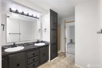 View from your beautiful primary en-suite bathroom towards primary bedroom. Notice the double vanity with upgraded lighting and fixtures. Brand new walk in shower lies directly to the right.