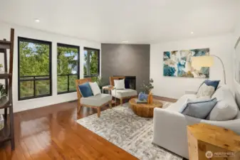 Bright living room with fireplace and expansive windows framing Lake Washington views