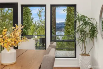 Dining room windows showcasing beautiful Lake Washington views through lush Pacific Northwest evergreens