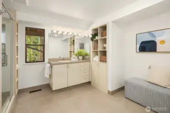 Generous lower-level bathroom with expansive vanity, glass shower, and custom built-in storage