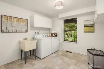 Oversized laundry room offering a utility sink, built-in cabinetry, and generous space for storage, organization, and daily functionality