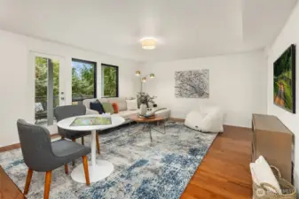 Bright and versatile lower-level rec room with hardwood floors, expansive windows overlooking the surrounding greenery, and walk-out access to a private deck