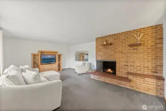 Floor to ceiling brick  fireplace that is wood-burning fireplace, stone hearth, large windows, and fabulous vintage mirrors!