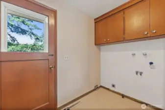 Laundry room with cabinetry and door to back deck