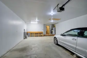 Another view of extra deep garage with work bench and shelves
