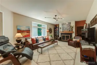 Family room with views of the lush greenbelt. Double sided gas fireplace, and door to main floor rec room/bonus room.