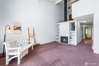 Soaring ceilings, built in shelves and a comfy fireplace are great features of the living room/dining room combo.  Down the hallway is the entry to the Primary bedroom on the main level.  Yes, new flooring and paint will probably be one of the buyer's first investments, we know