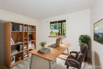 Comfortable first bedroom with soft light and space to relax or work. Virtually staged.