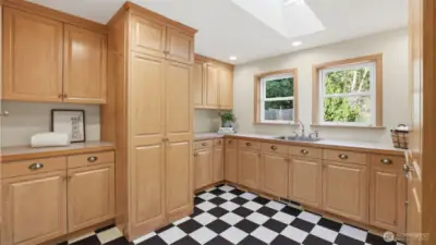 Laundry won't feel the same in this main floor utility room with an abundance of thoughtfully designed custom cabinets.