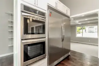 High-end appliances, oversized refrigerator, double oven, dishwasher and gas range with built in vent.