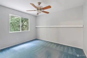 One of the 4 bedrooms upstairs w/ceiling fan and view of backyard.