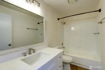Main bath with new vanity, mirror, lights and flooring.