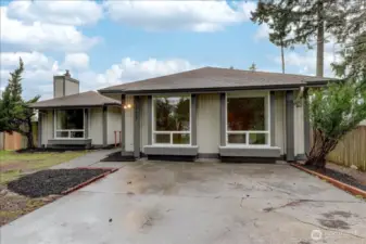 Front driveway area with the front section converted to living space. 4th bedroom on the left and bonus/rec room  on the right with an outside entrance on the right side of the home.